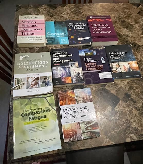 Several textbooks lying flat on a table, all related to library and information science