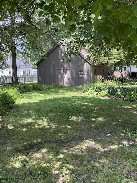 Restored brown barn at back of a garden