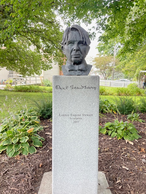 Bust of Carl Sandburg on a pedestal in a garden
