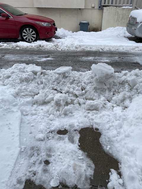 Wall of plowed snow chunks blocking a walkway