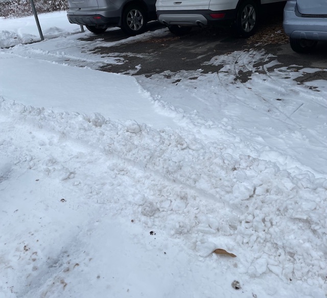Snow piled up behind three cars