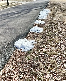 Small piles of snow along the edge of the road.