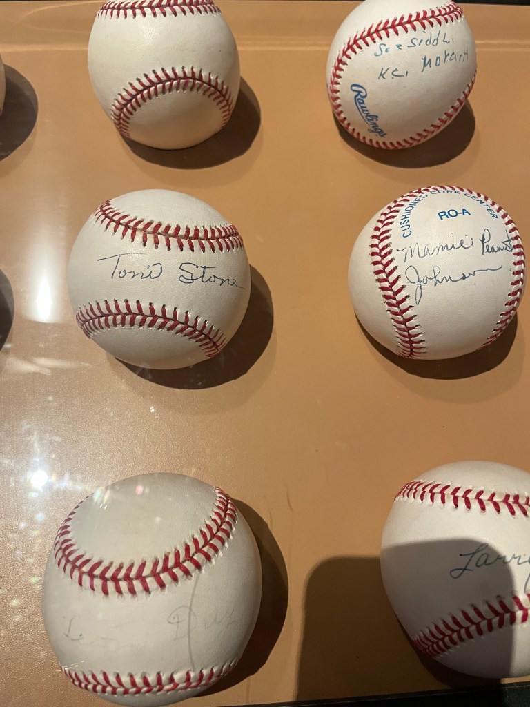 6 autographed baseballs. One says Toni Stone, another Mamie Peanut Johnson.