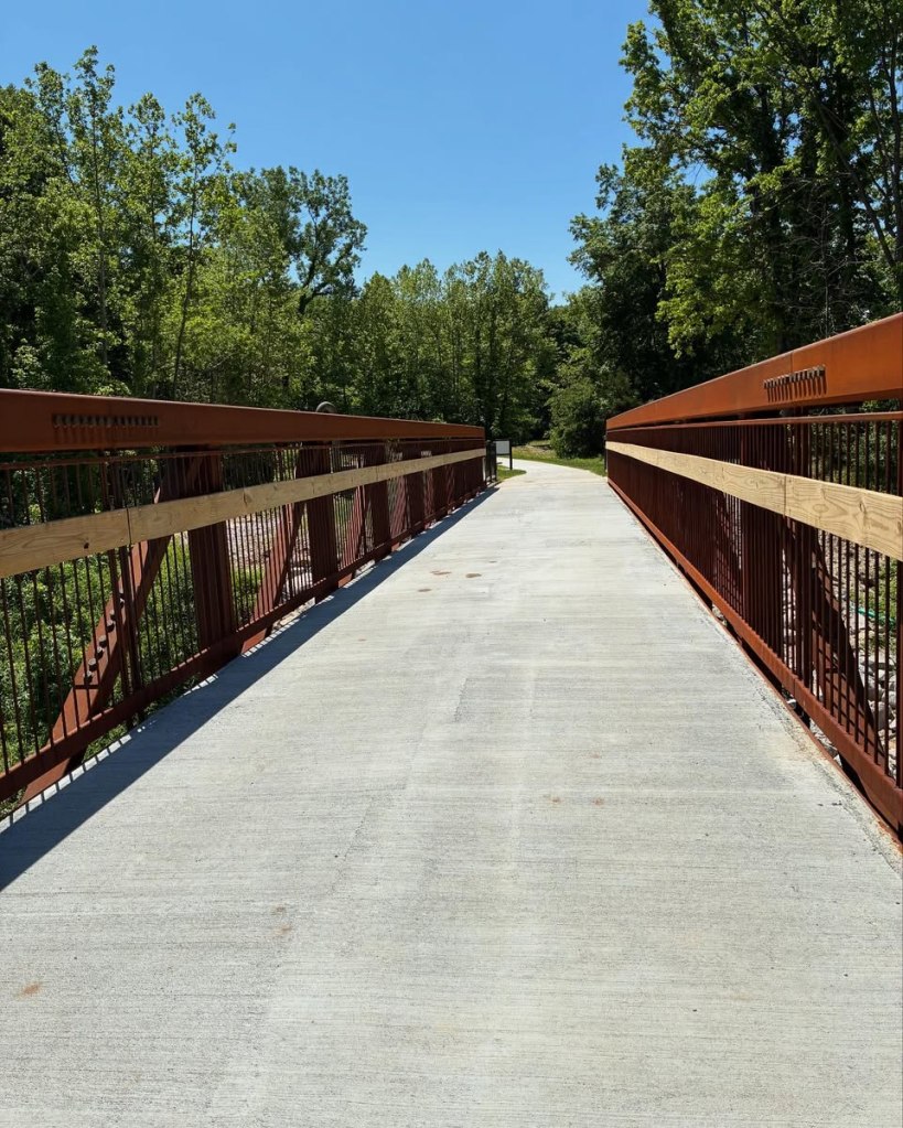 Paved trail bridge with tall rails on either side.