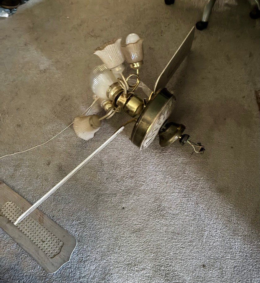 ceiling fan light fixture lying in pieces on a carpet