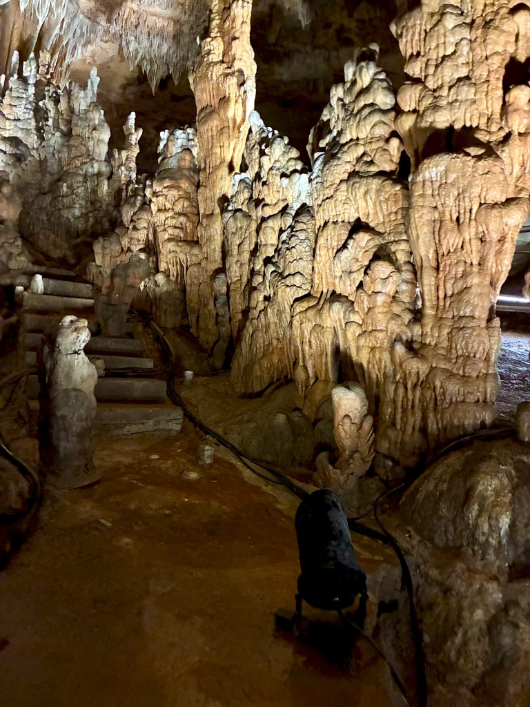 Stairway inside a tourist cave, with pillars rising on either side.